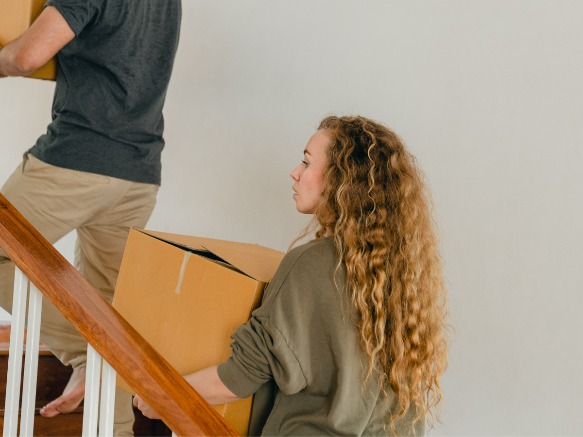 Woman moving boxes upstairs