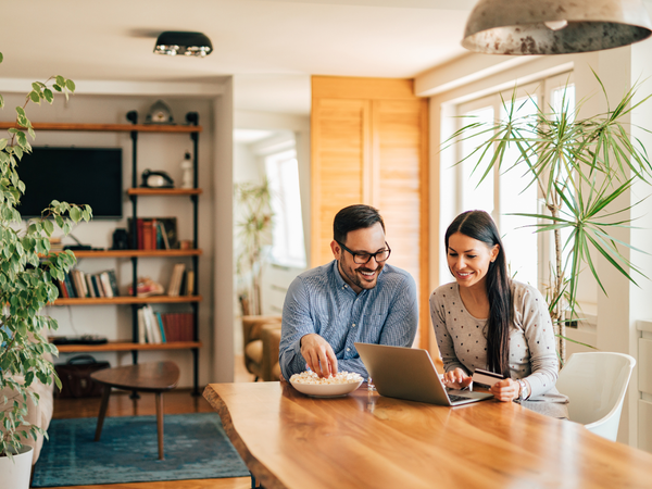 couple sat at table with laptop