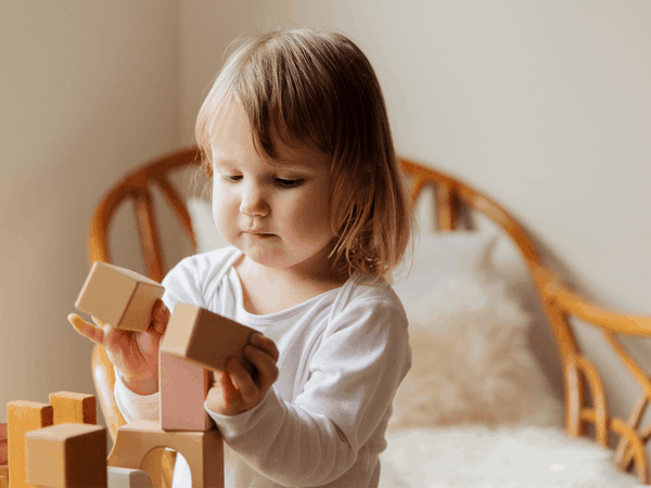 child playing with wooden blocks